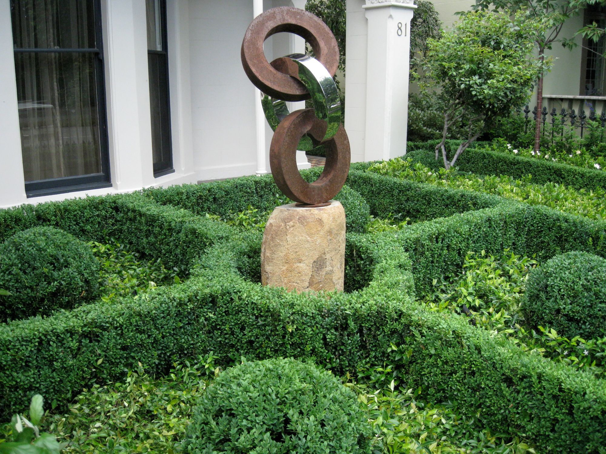 Middle Park garden — a sculptural knot garden of clipped box with corten and polished steel sculpture